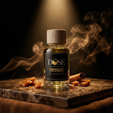 Bottle of 'stronger with you intensely' with cinnamon sticks and smoke on a dark background